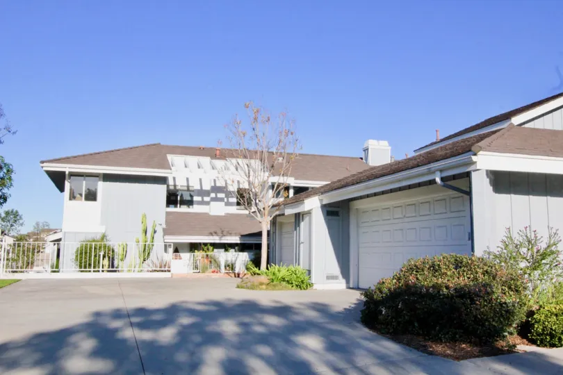 THE SIDEVIEW OF HOUSE WITH SHEDS, EMPTY SPACES, PLANTS, TREES ARE THERE IN IRVINE CITY