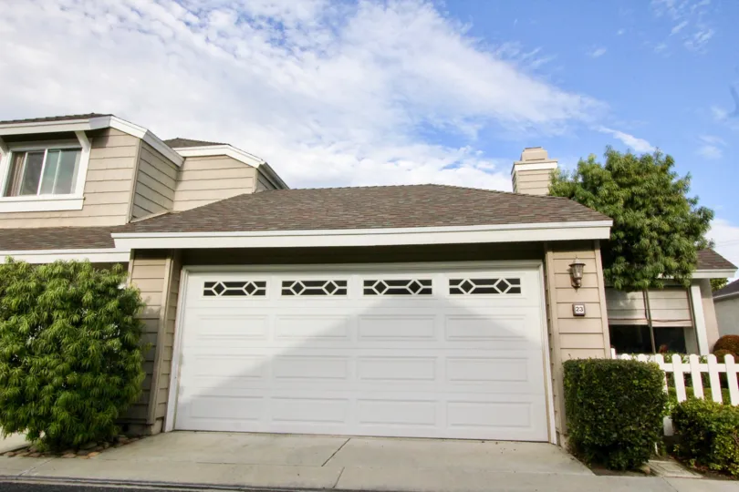 A closed carport in the Windwood Garden Homes community with brownish houses.
