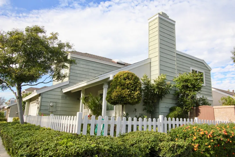 A street view of a home and landscaped yard on a sunny day in Windwood Garden Homes