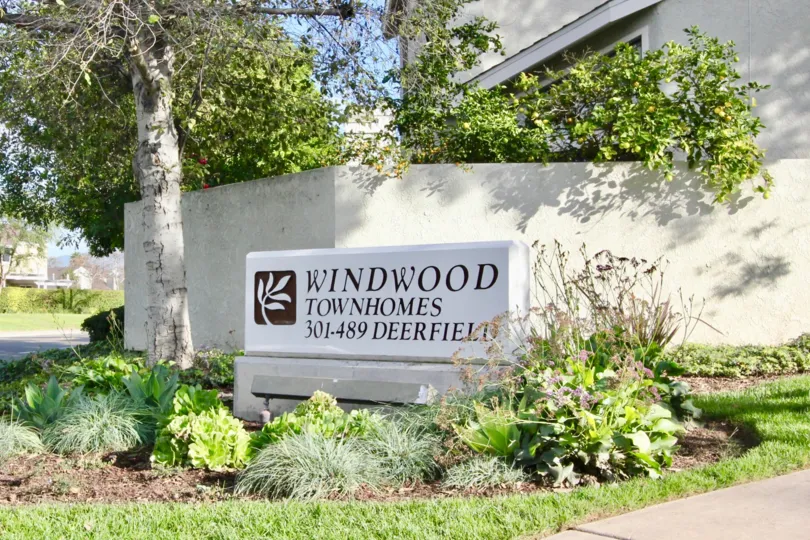 A lovely variety of plants surrounding a sign advertising the Windwood Townhomes