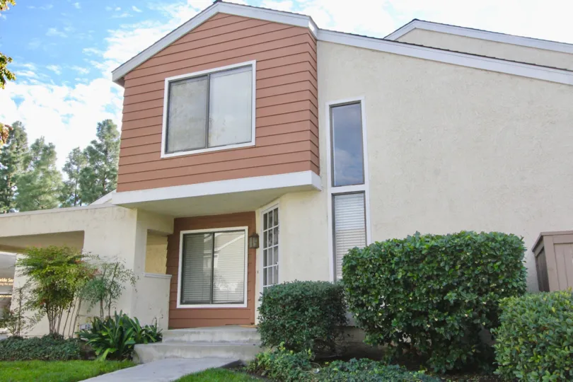 View of the front of house with shrubs in Windwood Townhomes community in Irvine, California