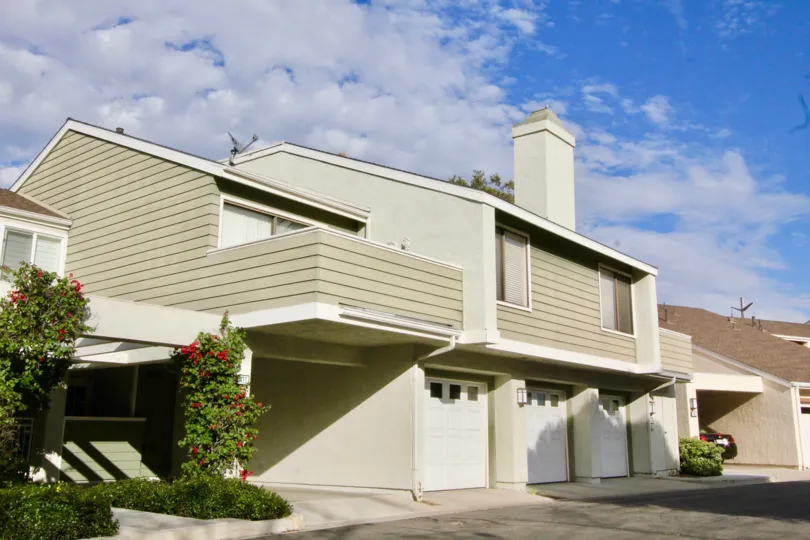 Paneled townhomes with garages and floral creepers in the front