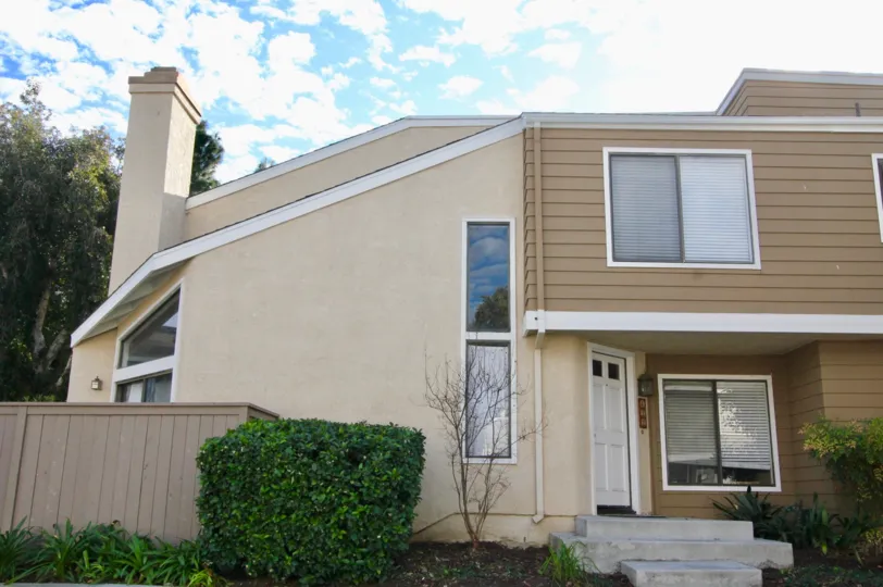 THE FRONT VIEW OF THE HOME WITH MANY GLASS WINDOWS, AND SHOWS THE PLANTS IN IRVINE CITY