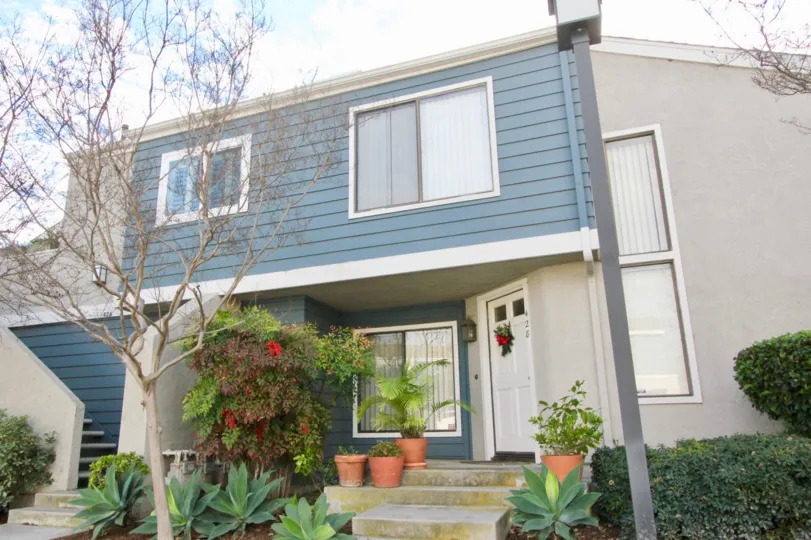front entrance view of the building decorated with plants and flowers in Windwood Townhomes