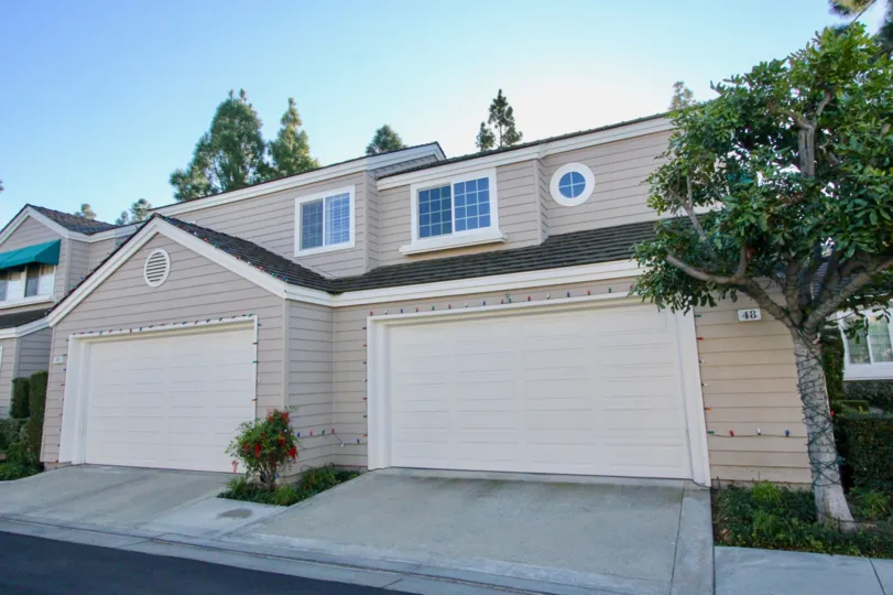 Two large white garage doors attached to gray homes at Woodbridge Cove in Irvine CA