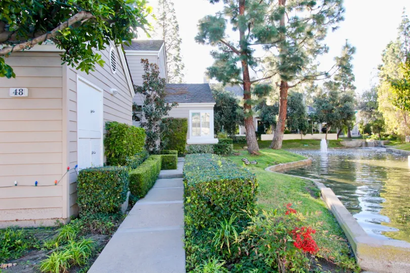 A backyard of a residence in the Woodbridge Cove community with a pond and a small fountain.