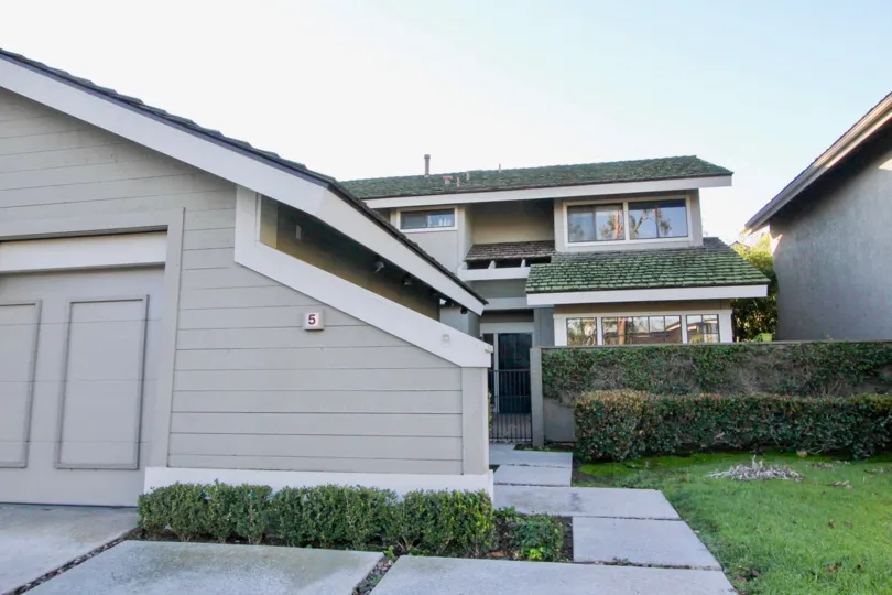 A house with grey walls and green sloped roofs inside Woodbridge crossing community