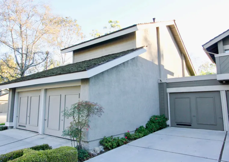 A corner view of a two-storey residence in the Woodbridge Crossing community with closed carports.
