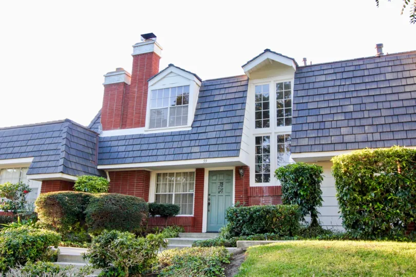 A large beautiful home with lots of windows and green shrubbery