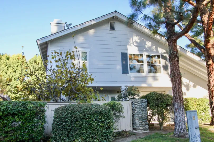 A sunny day in the Woodbridge Estates with green shrubs around the home.