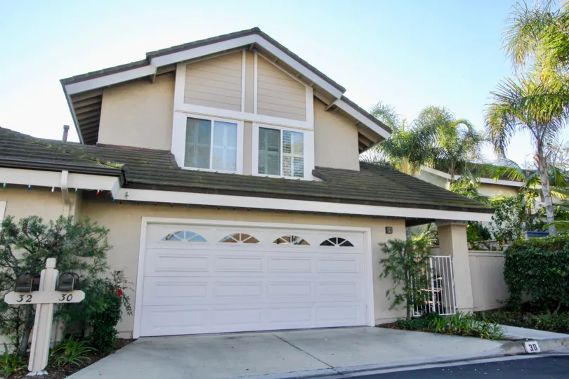 A two-storey residence in Woodbridge Grove community with closed carport and moldy roof.