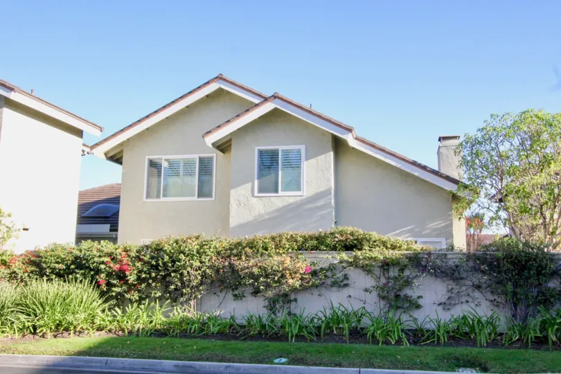 A large home with a wall around it in the Woodbridge Grove community in Irvine, California.