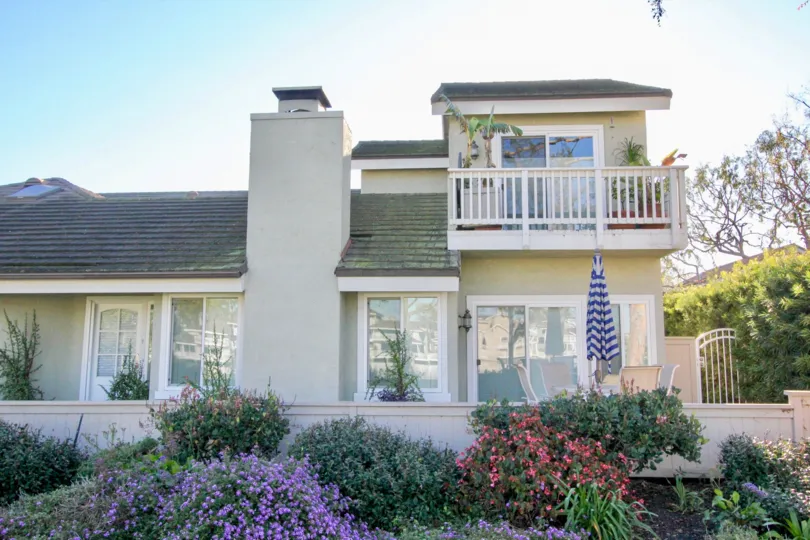 A Beautifil sunny day In the surburban town of Irvine Caifonia showing a beautiful home with a top floor balcony