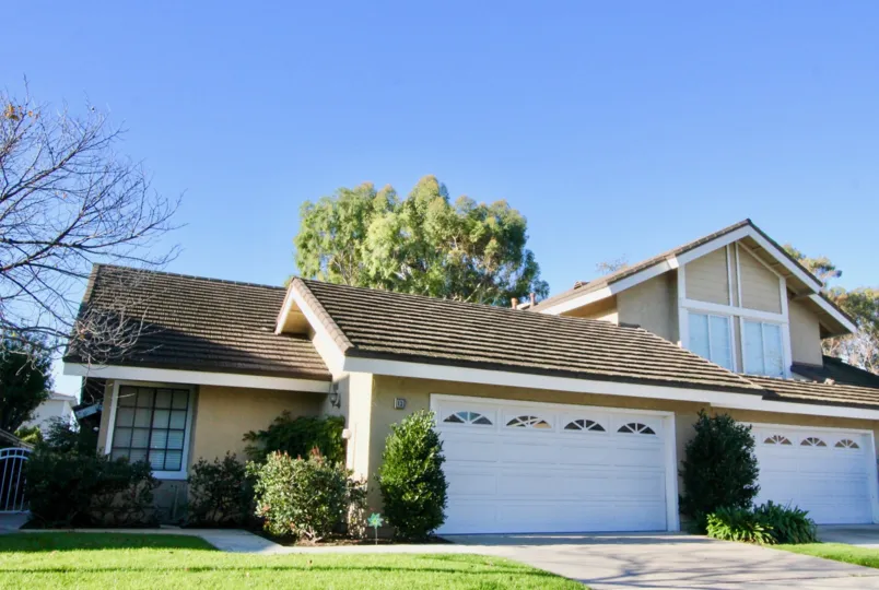A beige painted suburban house with two garages on the neighborhood of Woodbridge Grove