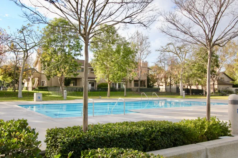 a pleasant day in the woodbridge laurels with a building that has swiming pool and around trees