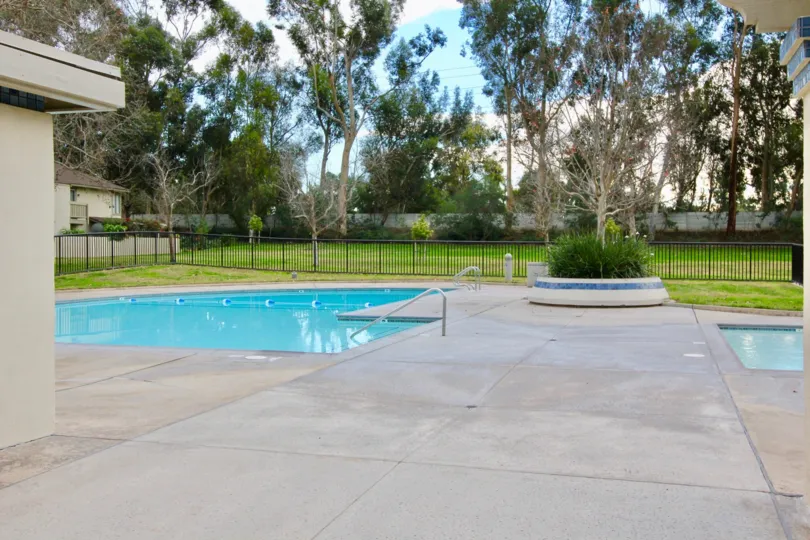 A beautiful swimming pool in the Woodbridge Reserve with some trees and lawn.