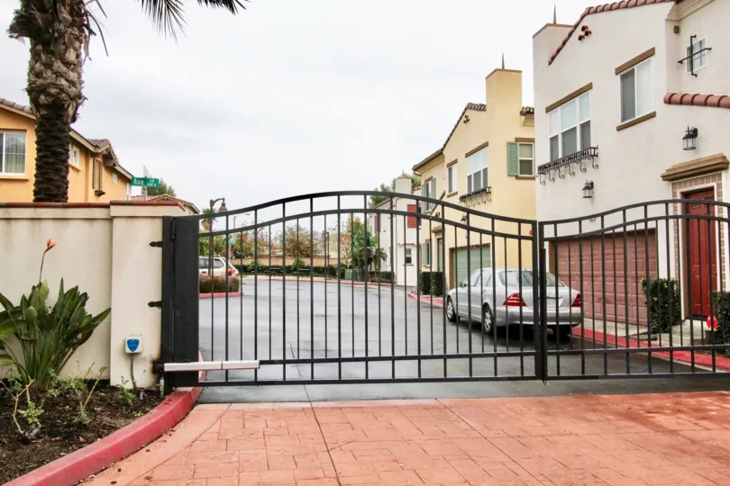 The entrance gate and a white and yellow stucco buildinga at the Avo community