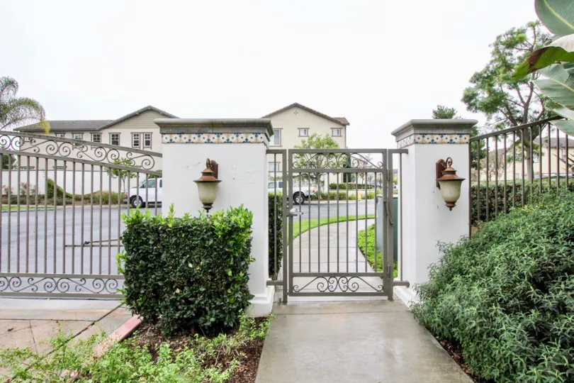 A estate in brio with beautiful front gate. surrounding is full of garden with plants and trees.