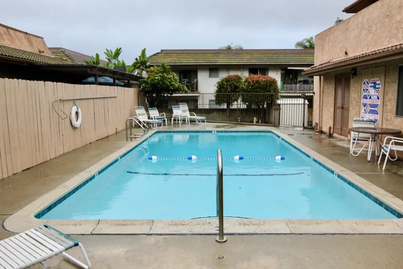 A blue color swimming pool in Cerro Del Rey with some chairs.