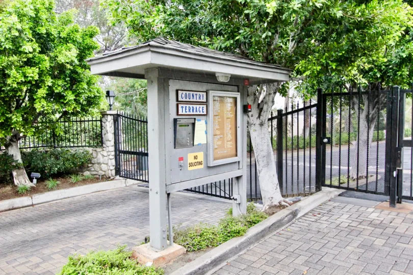 a warm day in the country terrace with a park that has entrance gate closed and garden around