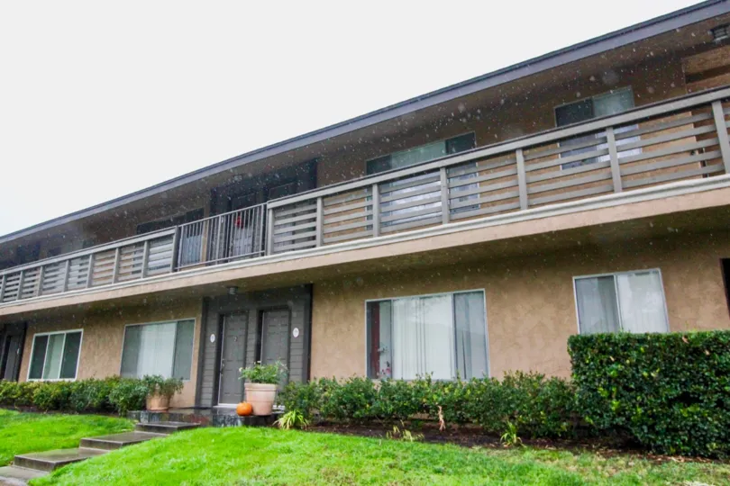 a pleasant day in the creedside village with a house that has balcony and steps in center and garden around