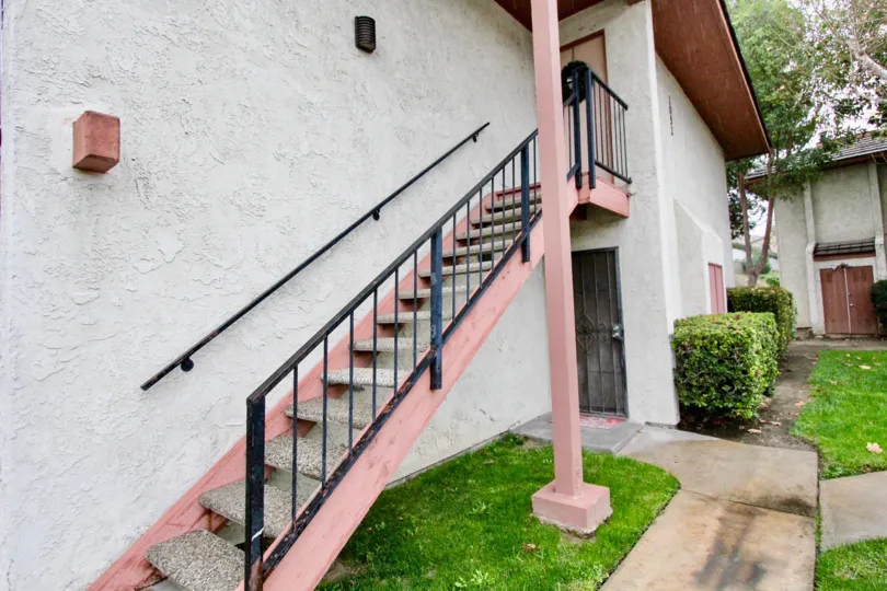 A rose painted staircase in the Fashion Heights with some plants.
