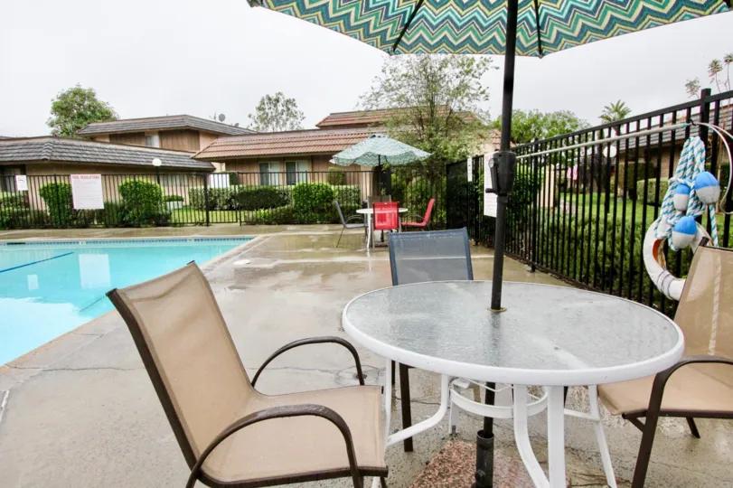 A table and chair in the Fashion Walk with swimming pool.