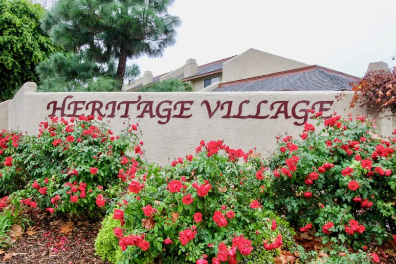 a pleasant day in heritage village with a building that has stone walls and flowers garden around