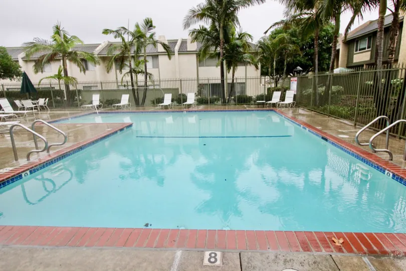 The pool and lounge chairs and palms at the Heritage Village community