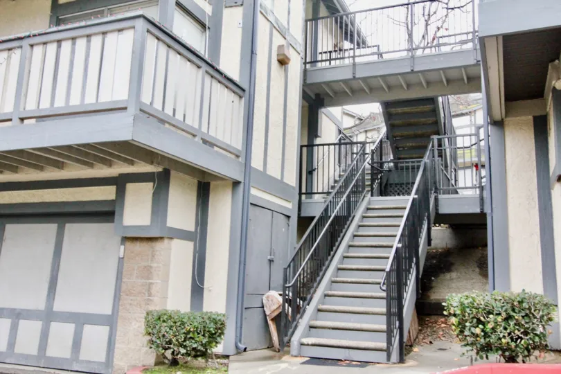 A set of gray stairs with black hand rails inside Heritage Walnut in La Habra CA