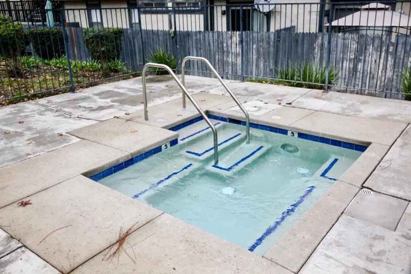 A small swimming pool in the Heritage Walnut covers with some iron grill and some shrubs.