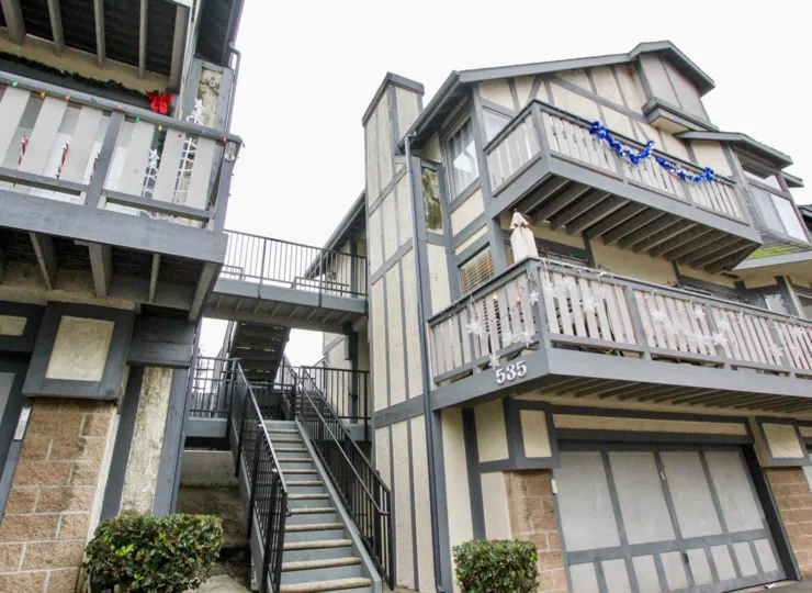Some apartments near the road side in the Heritage Walnut with some shrubs.