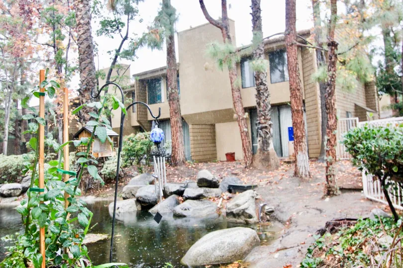 THIS IMAGE VIEWS THE HOUSE ON THE FRONT LOT OF TREES, PLANTS, BIG STONES ARE THERE IN LA HABRA CITY
