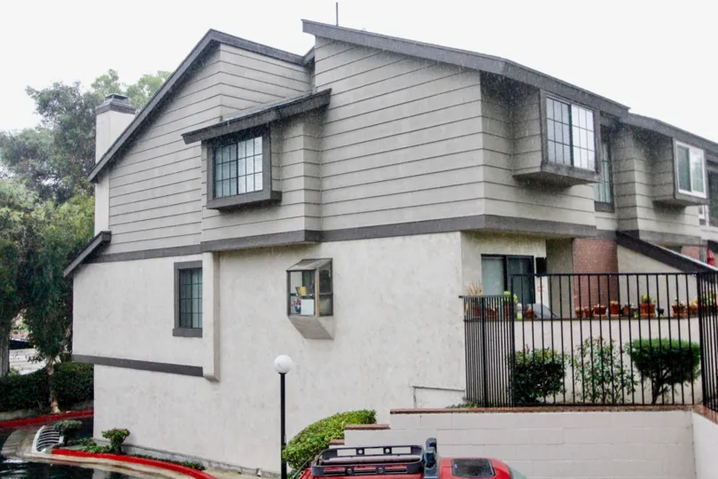 THE BUILDING IN THE LA HABRA WOODS TOWNHOMES WITH THE FLOWER POTS, PLANTS, TREES
