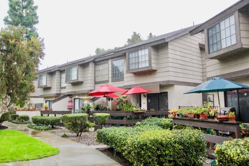 THE BUILDING IN THE LA HABRA WOODS TOWNHOMES WITH THE UMBRELLAS, FLOWER POTS, LAWN