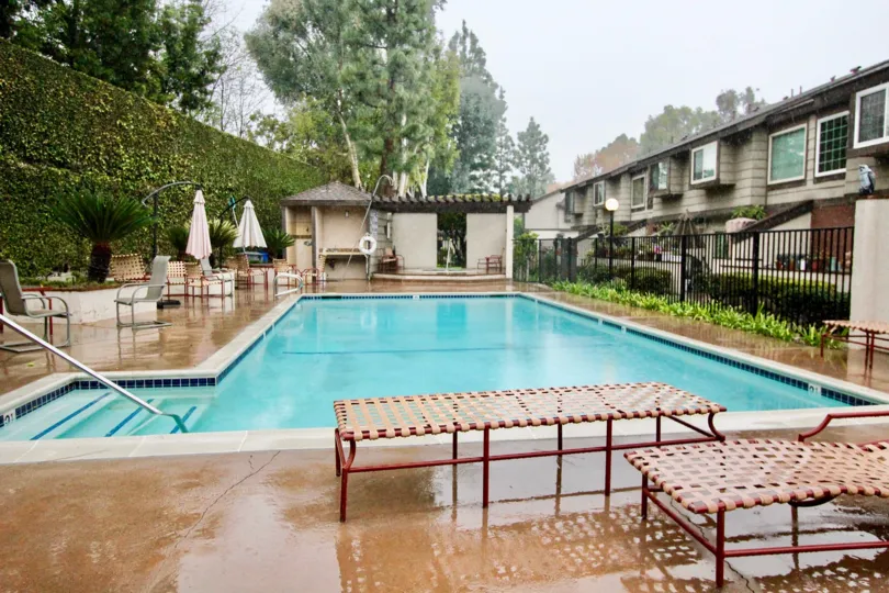 A PLEASANT DAY IN THE La Habra Woods Townhomes WITH A BUILDING THAT HASswimmingpool AND RESTING TABLES
