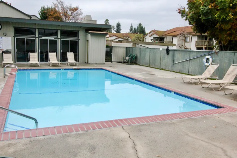 a rainy day in the lakeview townhomes with a building that has swiming pool and resting chais