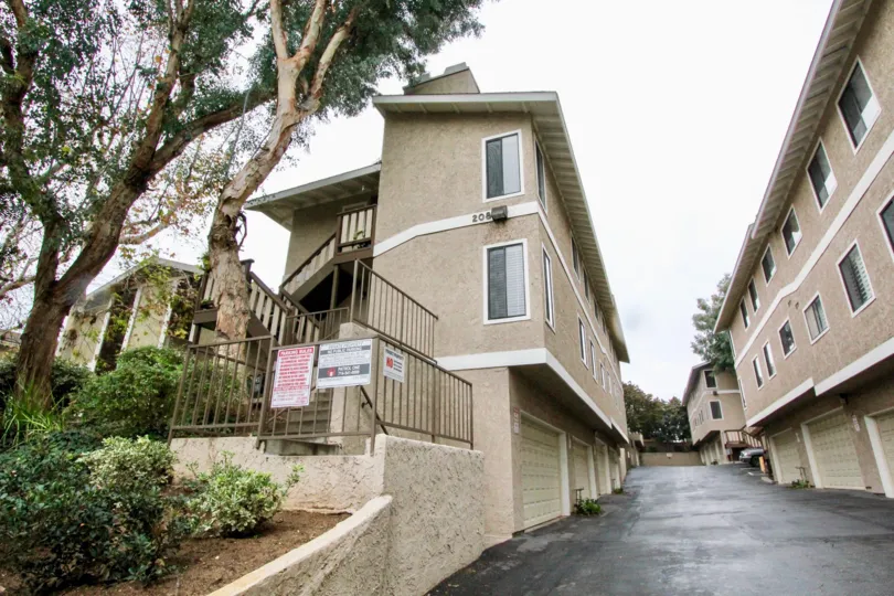 Side view of two apartments in Oliveview with some trees.