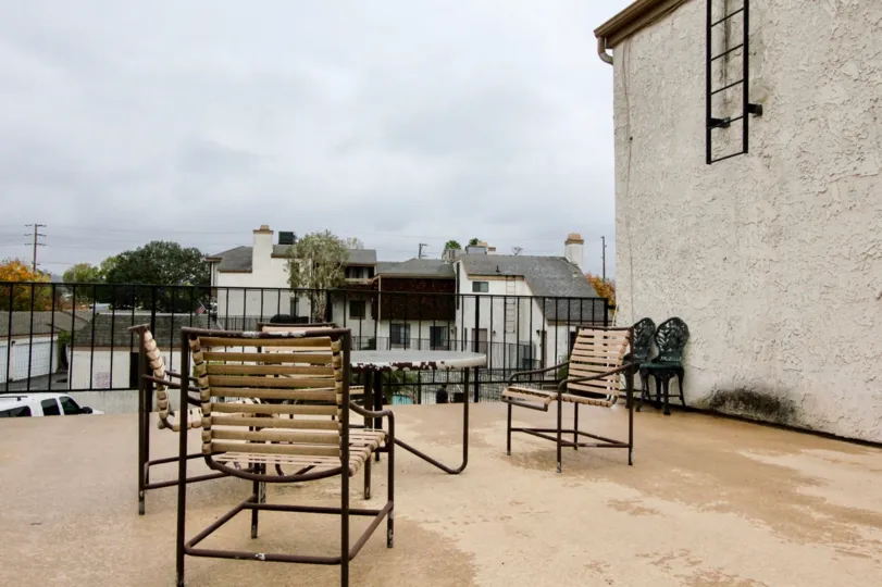 a rainy day in the parkside town homes with building that has tinning table and 3 chairs