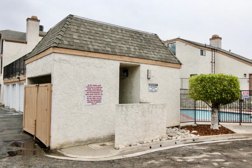 A small house in the Parkside Townhomes City: La Habra with a plant and gate.