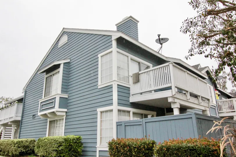 THE APARTMENT IN THE STONE HARBOR WITH THE DISH ANTENNA, TREES, PLANTS