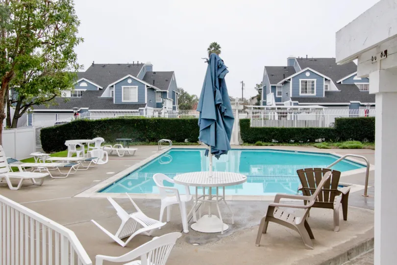 a pleasant day in the stone harbor with a swiming pool that has dining table and scrubs in the right side