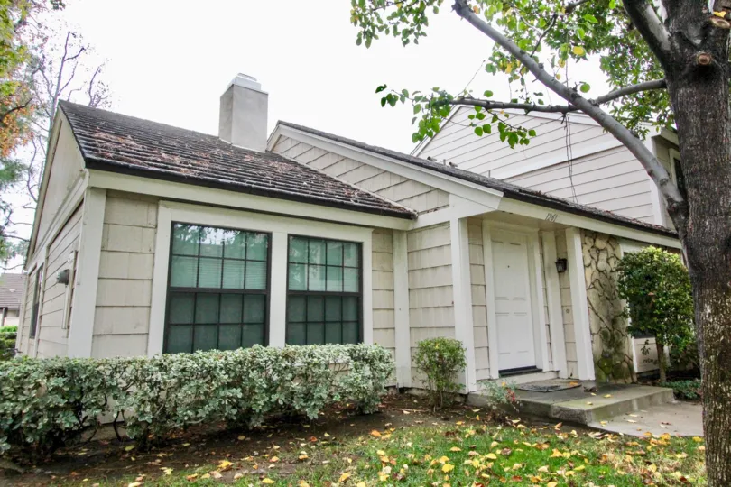 THIS IMAGE SHOWS THE SIDE VIEW OF HOME IN LA HABRA THAT SHOWS LOT OF SMALL PLANTS LIKE CROTONS