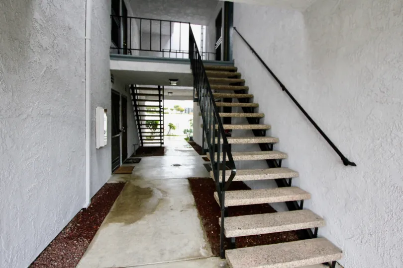 An exterior flight of stairs and entrances to several units in Woodlake Village