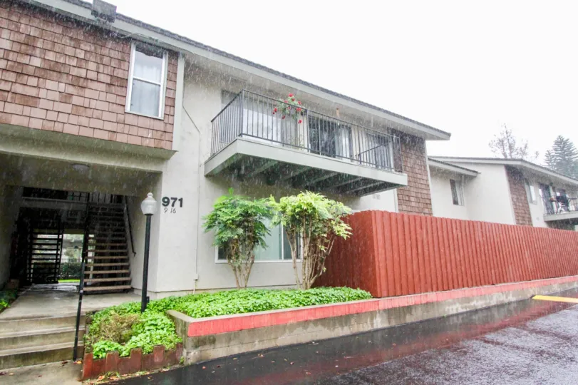 a rainy day in the woodlake villas with a house that has numbered as 971 and compound walls and garden in front