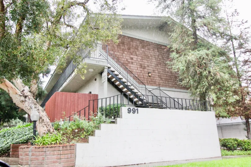 A day in the Woodlake Villas with a staircase and tree.