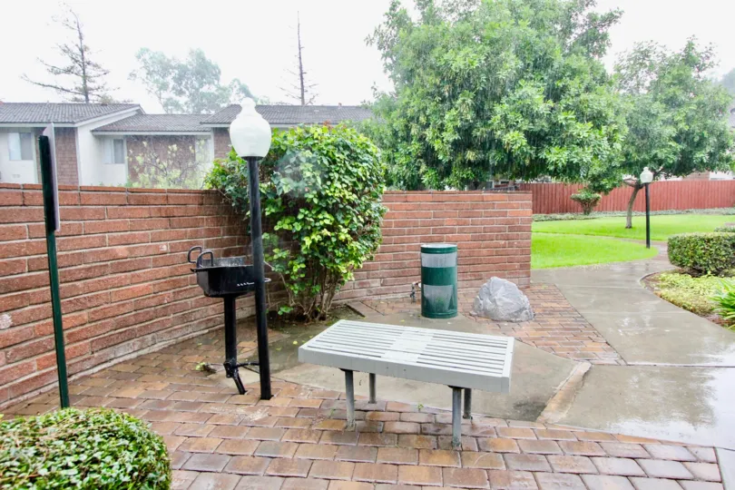 THE SIDE OF THE HOUSE BRICK REDSTONE WALL IS THERE, PATHWAY, LAWN, TREES, LIGHT LAMPS ARE THERE IN LA HABRA CITY