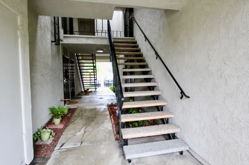 A staircase in the Woodlake Villas with some plants on the floor.