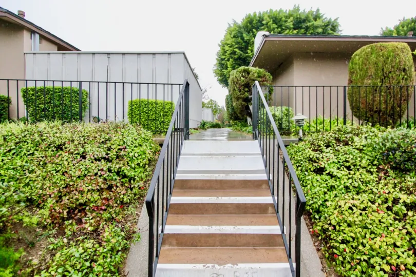 A brown and gray staircase with black railing inside Woodridge Townhouse in La Habra CA