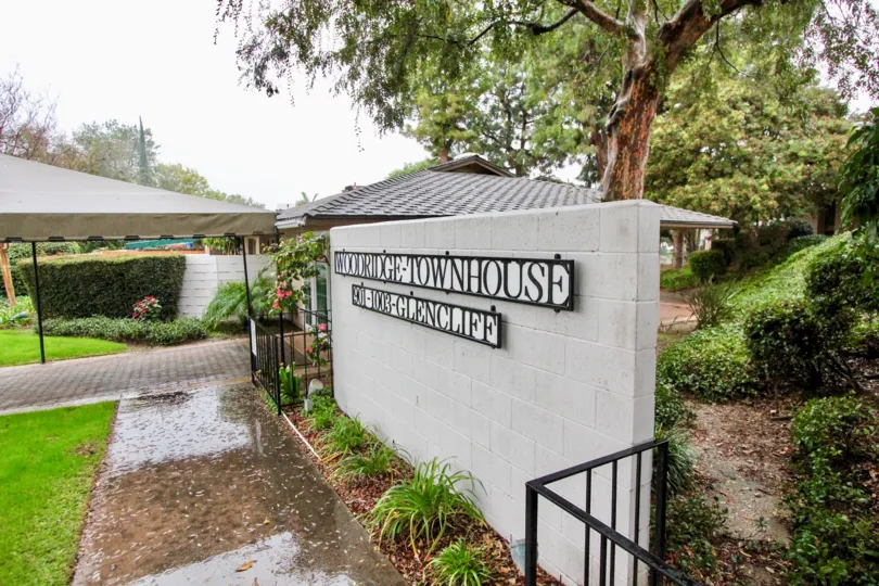 a rainy day in the woodridge town homes with a park that has stone walls and garden around